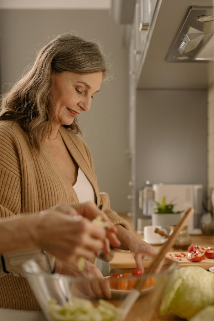 Elderly woman preparing a healthy meal in a bright, modern kitchen environment.